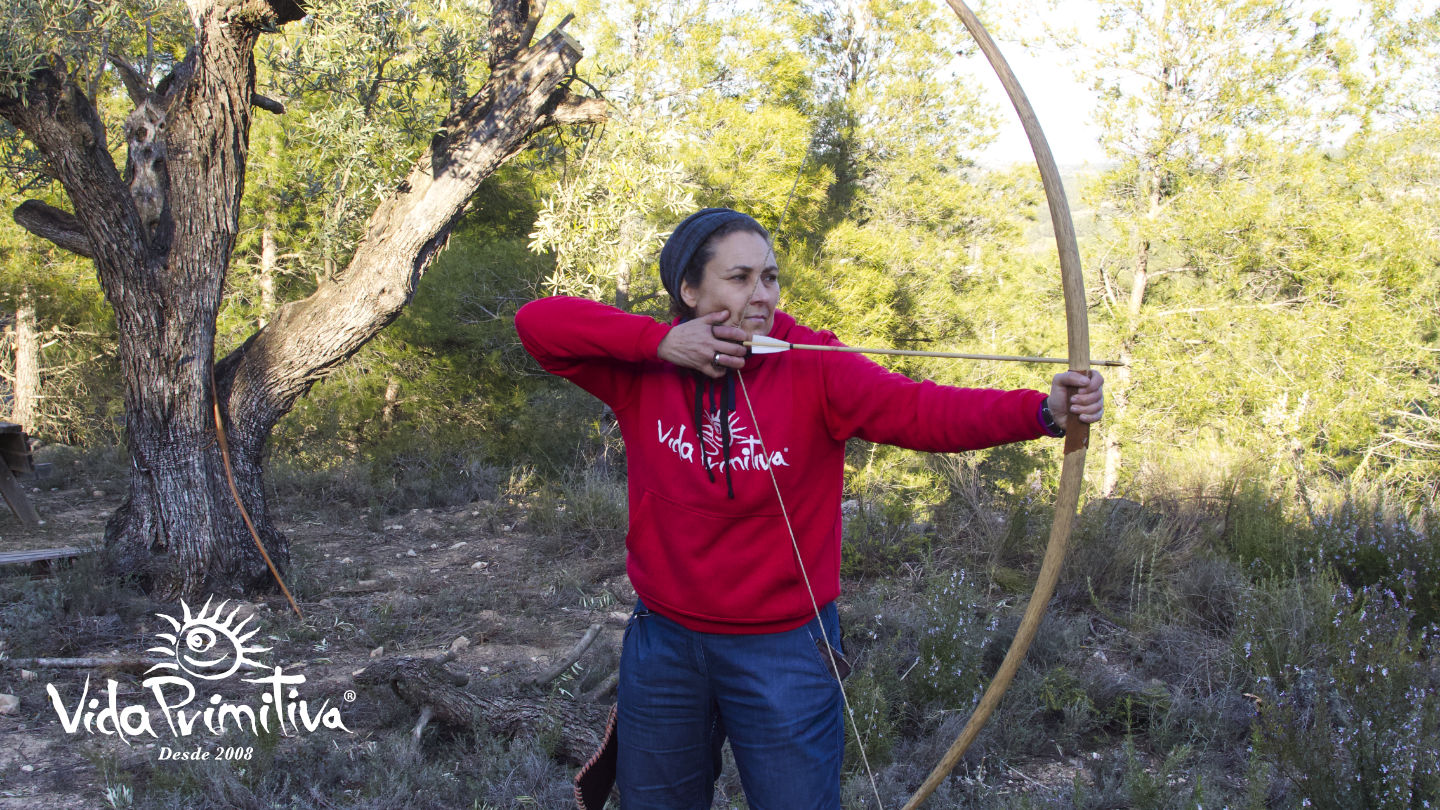 Eva tirando con arco primitivo