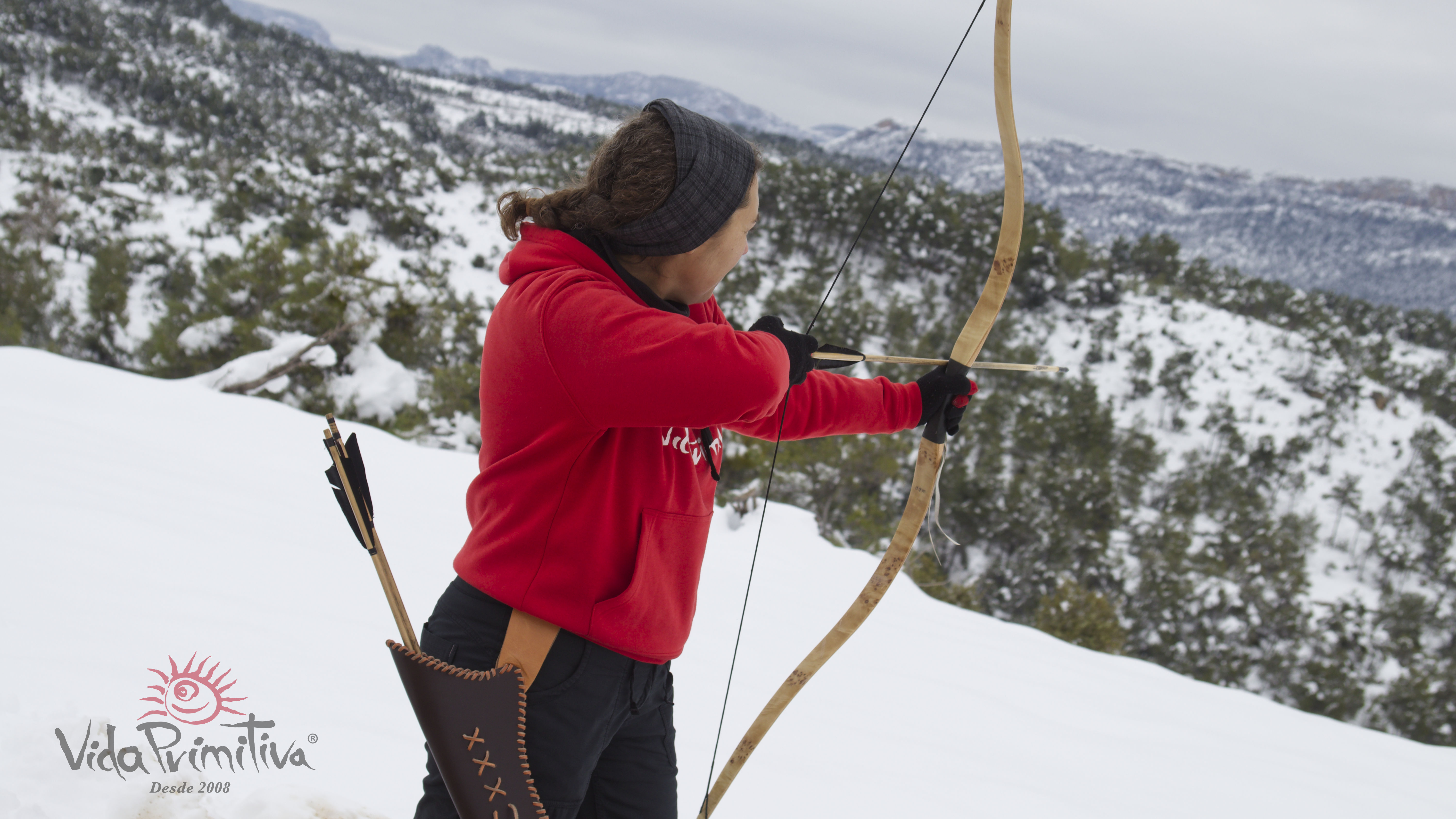 Eva tirando con arco en la nieve